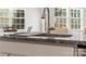 Close-up of a granite kitchen island with stainless steel faucet and dining nook in background at 3036 Whipcord Dr, Waxhaw, NC 28173