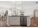 Open kitchen layout with granite island, stainless dishwasher and view to living and dining areas at 3036 Whipcord Dr, Waxhaw, NC 28173