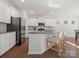 A modern kitchen boasts stainless steel appliances, a central island with bar seating, and white cabinetry at 3036 Whipcord Dr, Waxhaw, NC 28173