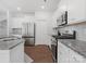 Well-lit kitchen featuring stainless steel appliances, granite countertops, and white cabinets at 3036 Whipcord Dr, Waxhaw, NC 28173
