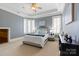 Light-filled bedroom with a tray ceiling, plantation shutters and an inviting queen-sized bed at 325 Ivy Arbor Cir, Rock Hill, SC 29732