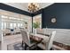 Elegant dining room with dark blue walls, chandelier, and formal dining set, with a view to outside at 325 Ivy Arbor Cir, Rock Hill, SC 29732
