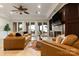 Elegant living room with a fireplace, leather sofas, and a stunning lake view through large glass doors at 325 Ivy Arbor Cir, Rock Hill, SC 29732