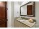Elegant powder room with granite counters, a decorative mirror and a rich wood door at 325 Ivy Arbor Cir, Rock Hill, SC 29732
