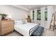 Bright bedroom with white bedding, light wood furniture, and natural light from large windows at 3526 Saker Ln, Charlotte, NC 28211