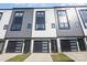 Contemporary townhome showcasing a sleek design with mixed materials and black garage doors at 3526 Saker Ln, Charlotte, NC 28211
