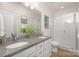 Modern bathroom with double sinks, granite countertops, a large mirror, and a tiled glass-enclosed shower at 3708 Small Ave, Charlotte, NC 28269