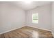 Minimalist bedroom with hardwood flooring, a window, and neutral walls, creating a serene atmosphere at 3708 Small Ave, Charlotte, NC 28269