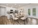 Well-lit dining room with a modern glass table, seating for six, and easy access to the kitchen at 3708 Small Ave, Charlotte, NC 28269