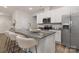 Contemporary kitchen featuring a large island with seating, stainless steel appliances, and sleek white cabinetry at 3708 Small Ave, Charlotte, NC 28269