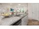 Bright kitchen featuring granite counters, stainless steel appliances, and an open layout to the living area at 3708 Small Ave, Charlotte, NC 28269