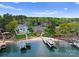 Stunning aerial view of lakefront homes with manicured lawns, private beaches, and boat docks at 3988 Channel Point Ln, Denver, NC 28037