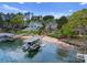 Beautiful waterfront property featuring lush landscaping, a private beach, and a boat dock for lake access at 3988 Channel Point Ln, Denver, NC 28037