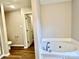 Bathroom showcasing a soaking tub with chrome fixtures and a view into the adjacent water closet at 4418 Palustris Ct, Charlotte, NC 28269