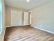 A clean bedroom featuring wood-look floors, neutral walls, closet, and door to hallway at 4418 Palustris Ct, Charlotte, NC 28269