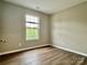 Bedroom with wood-look flooring, a large window, and neutral paint at 4418 Palustris Ct, Charlotte, NC 28269