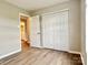 Bedroom featuring wood-look floors and a glimpse into the ensuite bathroom and closet at 4418 Palustris Ct, Charlotte, NC 28269