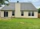 Back exterior view of home with siding, sliding door, green lawn, and chimney at 4418 Palustris Ct, Charlotte, NC 28269