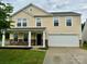 Charming two-story home featuring a covered front porch, stone accents, and a two-car garage at 4418 Palustris Ct, Charlotte, NC 28269