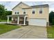 Inviting two-story home with a covered porch, stone details, and a spacious driveway leading to the garage at 4418 Palustris Ct, Charlotte, NC 28269