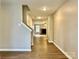 Open hallway with wood floors leading to a living area featuring a stone fireplace and natural light at 4418 Palustris Ct, Charlotte, NC 28269