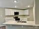 Modern kitchen with white cabinets, quartz countertops, stainless steel appliances, and a peninsula island at 4418 Palustris Ct, Charlotte, NC 28269