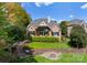 Beautiful backyard featuring a brick home, a well-manicured lawn, and a stone fire pit area at 4628 Sierra View Dr, Denver, NC 28037