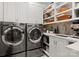 The modern laundry room has stainless steel appliances, counter space and built in shelves at 4628 Sierra View Dr, Denver, NC 28037