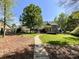 Spacious backyard with a lush lawn, mature trees, a stone walkway, and an entertainment area at 4823 Antioch Church Rd, Weddington, NC 28104