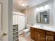 Well-lit bathroom featuring a toilet, a shower with a curtain, a mirror, and vanity at 4823 Antioch Church Rd, Weddington, NC 28104