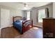 Bedroom features a wooden bed, hardwood flooring, natural lighting, and a ceiling fan at 4823 Antioch Church Rd, Weddington, NC 28104