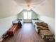 Attic bedroom with hardwood flooring, two beds, a couch, and natural lighting at 4823 Antioch Church Rd, Weddington, NC 28104
