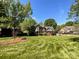 Expansive front yard showcasing a well-maintained lawn, mature trees, and a distinguished brick residence at 4823 Antioch Church Rd, Weddington, NC 28104