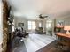 Comfortable living room featuring a stone fireplace, hardwood floors, a ceiling fan, and neutral colored walls at 4823 Antioch Church Rd, Weddington, NC 28104