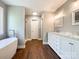 Bright main bathroom with a soaking tub, glass shower, and double vanity at 4823 Antioch Church Rd, Weddington, NC 28104