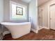Modern main bathroom with a standalone tub, glass enclosed shower, and neutral color palette at 4823 Antioch Church Rd, Weddington, NC 28104