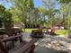 Outdoor patio with comfortable seating around a fire pit, surrounded by mature trees at 4823 Antioch Church Rd, Weddington, NC 28104