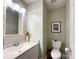 Elegant powder room with decorative mirror, white vanity, and framed artwork at 4823 Antioch Church Rd, Weddington, NC 28104