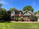 Stately two-story brick home with lush landscaping, mature trees, and a well-manicured lawn at 4823 Antioch Church Rd, Weddington, NC 28104