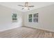 Well-lit bedroom with two windows, modern ceiling fan, and plank flooring at 507 E Green St, Monroe, NC 28112