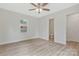 Spacious bedroom featuring two windows, plank flooring, ceiling fan and nearby bathroom at 507 E Green St, Monroe, NC 28112
