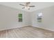 Light-filled bedroom featuring two windows, modern ceiling fan, and plank flooring at 507 E Green St, Monroe, NC 28112