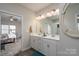 Bright bathroom with double vanity, white cabinets, and a glimpse into the bedroom at 530 Kiser Ln, Locust, NC 28097