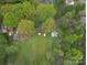 Aerial view of landscaped property featuring mature trees, grass, and outdoor structures at 5319 Springdale Ave, Mint Hill, NC 28227