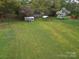 Expansive backyard featuring a shed, carport, and mature trees, providing ample space for outdoor activities at 5319 Springdale Ave, Mint Hill, NC 28227
