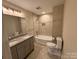 Bright bathroom featuring a dual sink vanity, tile flooring, and a shower-tub combo with tile surround at 5319 Springdale Ave, Mint Hill, NC 28227