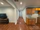 Hallway with wood floors featuring view down the hall with kitchen components and TV and table in the foreground at 5319 Springdale Ave, Mint Hill, NC 28227