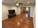 Spacious living room with hardwood floors, an entertainment center, and an open view to the kitchen at 5319 Springdale Ave, Mint Hill, NC 28227