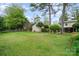 Spacious backyard with healthy green grass, trees, a detached garage and partial view of the house at 5329 Glenbrier Dr, Charlotte, NC 28212