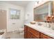 Bathroom featuring warm wood vanity, marble countertop, and decorative mirror at 5329 Glenbrier Dr, Charlotte, NC 28212